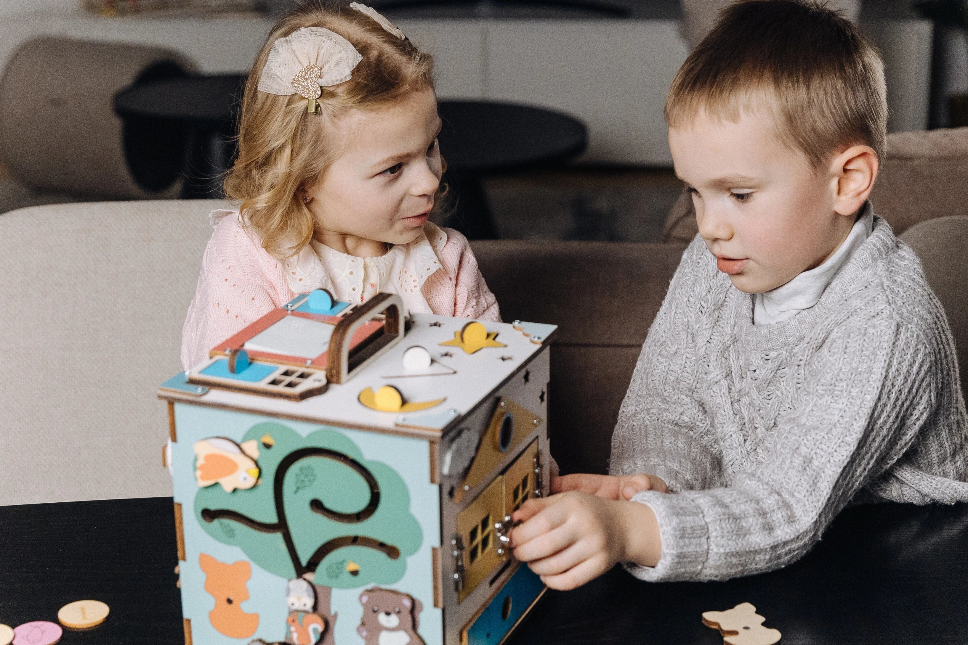 Toddler playing with wooden busy cube