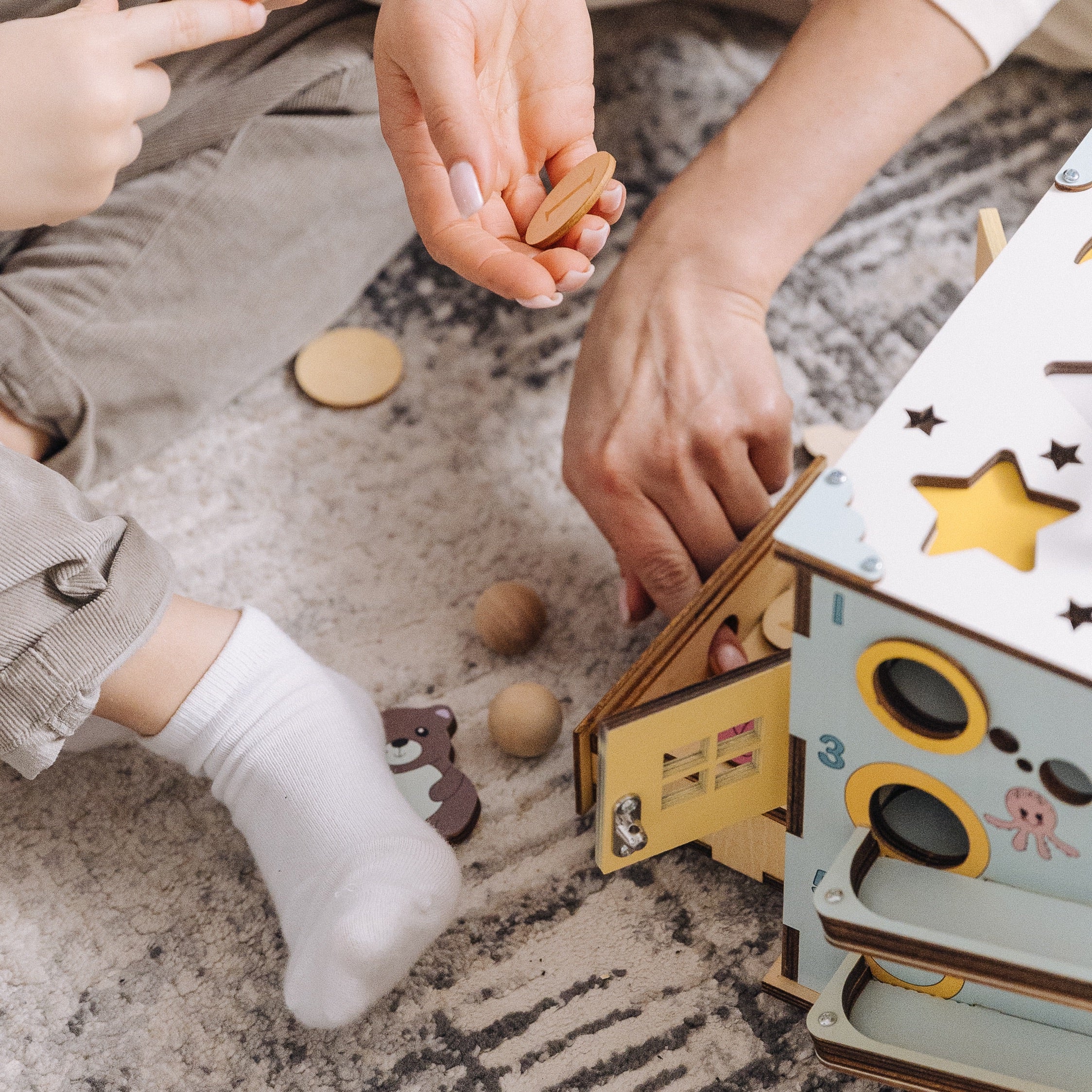 Toddler playing with wooden busy cube